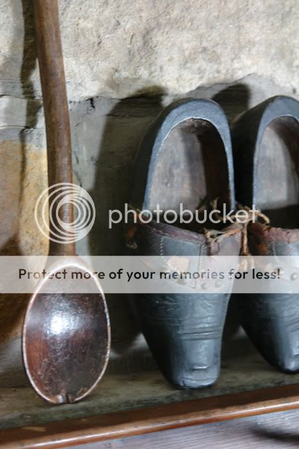 vintage wooden spoon with small antique clogs on mantlepiece